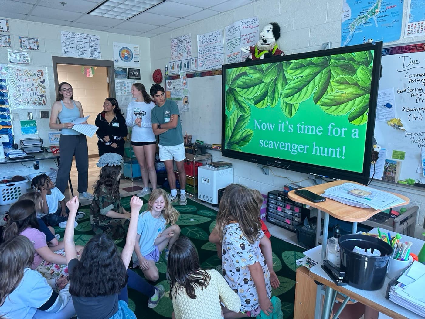 Mentors leading a native species scavenger hunt with elementary students